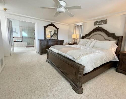 a bedroom with a large bed with a ceiling fan at Beach House located in quiet community. in Oxnard