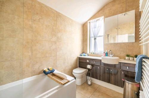 a bathroom with a tub and a toilet and a sink at The Mews - less than 1km to City Centre - Stadium - Castle - 10 min walk in Cardiff