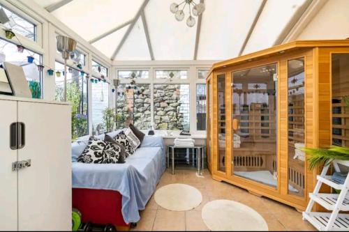 a conservatory with a couch in a room with windows at The Mews in Cardiff
