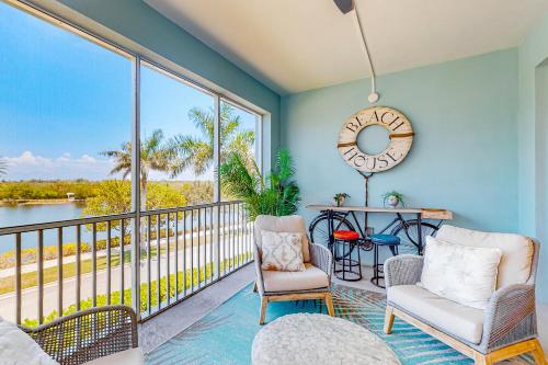 a room with a balcony with a table and chairs and a clock at Five O'Clock Somewhere in Bradenton