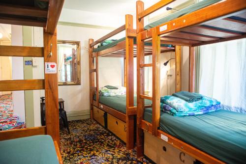 a room with three bunk beds and a mirror at Green Tortoise Hostel in San Francisco