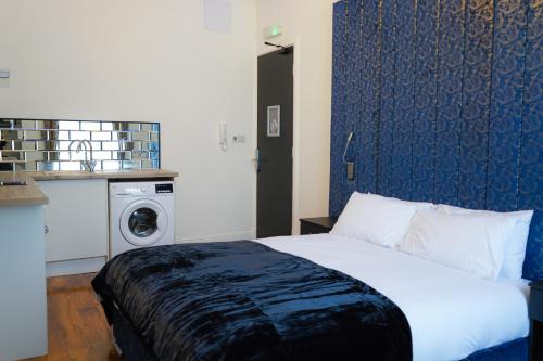 a bedroom with a bed and a washing machine at S.H Apartments in Glasgow
