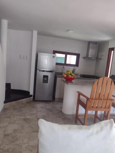 a kitchen with a stainless steel refrigerator and a chair at Cabañas Don Rafa Santa Marta in Santa Marta