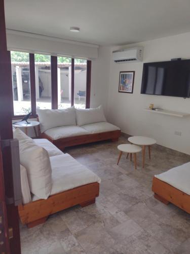 a living room with couches and a flat screen tv at Cabañas Don Rafa Santa Marta in Santa Marta