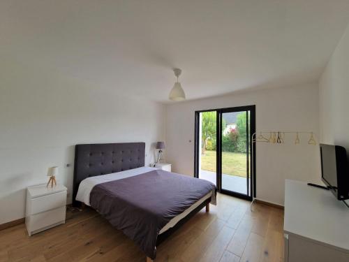 um quarto com uma cama e uma televisão em Comfortable holiday villa in a quiet location in Bénodet em Bénodet