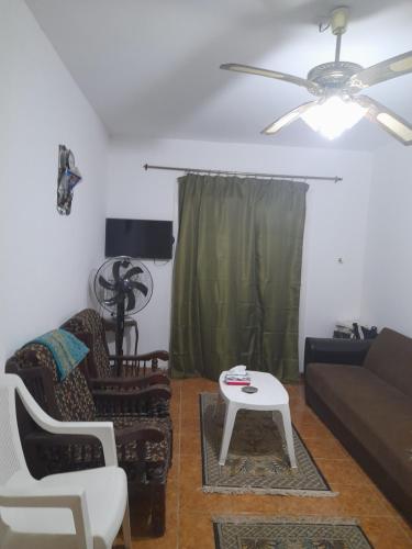 uma sala de estar com um sofá e uma mesa em مارسيليا بيتش ١ شاليه em Dawwār Abū al ‘Āşī