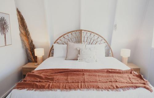a bedroom with a white bed with a wooden headboard at Reardon Retreat in Port Fairy