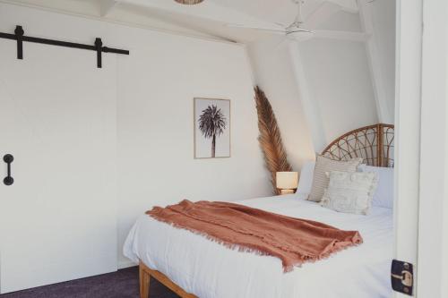 una camera da letto con un letto bianco con una coperta sopra di Reardon Retreat a Port Fairy