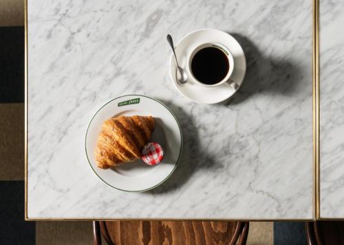 a plate of pastry and a cup of coffee on a table at Palihotel San Diego Gaslamp Quarter in San Diego