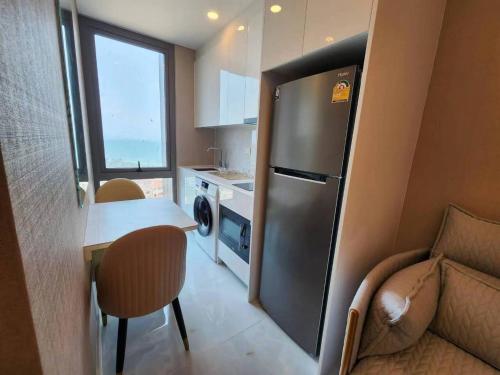een kleine keuken met een koelkast en een tafel en stoelen bij Copacabana jomtien condominium in Jomtien Beach