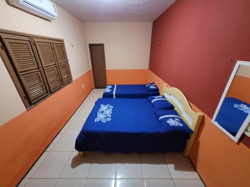 two beds in a room with red walls at Casa de praia, Camocim. in Camocim