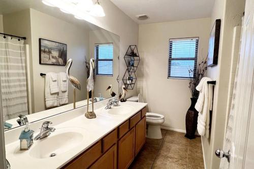 a bathroom with two sinks and a mirror and a toilet at La Posada de Lucy, LLC in Phoenix