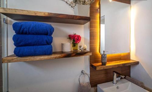 baño con una pila de toallas azules y espejo en Casa Tucan. A contemporary holiday or work nest en Puerto Morelos