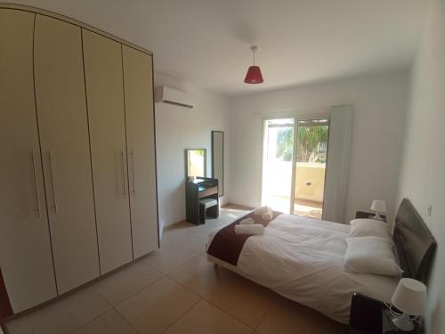 Un dormitorio con una cama grande y una ventana en 2 Bedroom Maisonette Mandria Paphos Cyprus, en Paphos