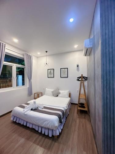 a bedroom with a large bed and a window at Sele House in Ha Tien