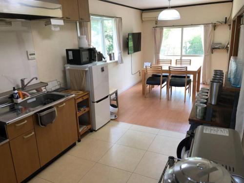 a kitchen with a sink and a table with chairs at Chichibu Mizuno-stay 水野ステイ最大６名様 in Chichibu