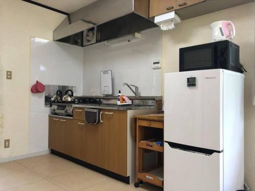 a kitchen with a white refrigerator and a sink at Chichibu Mizuno-stay 水野ステイ最大６名様 in Chichibu