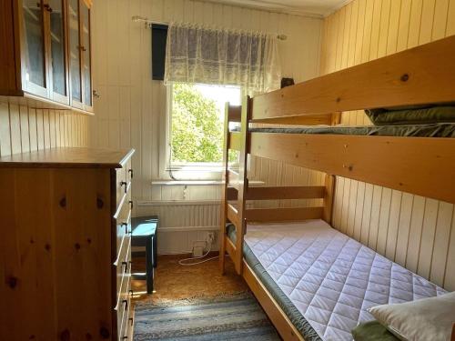 a room with two bunk beds and a window at Holiday home Nösund IX in Nösund