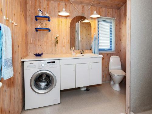 uma casa de banho com uma máquina de lavar roupa e um lavatório em Holiday home Pandrup XXXIII em Pandrup