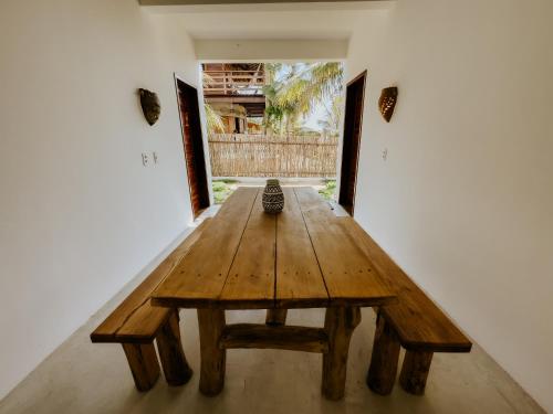 uma mesa de madeira no meio de uma sala em Vila Caiada Guest House em Luís Correia