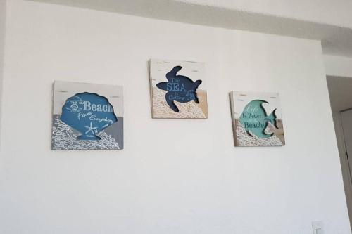 four cards on a wall with a heart and a shark at Departamento con vista al mar, albercas y juegos in Acapulco