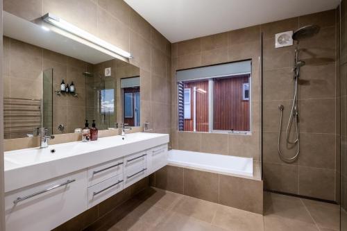 a bathroom with a tub and a sink and a shower at Halcyon ~ Immerse yourself in the sky and sea in Coles Bay