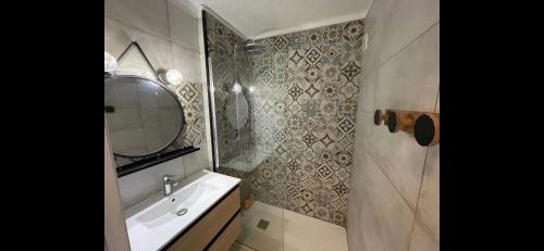 une salle de bain avec un lavabo et un miroir dans l'établissement Appartement Les Marines de Moriani, à San-Nicolao