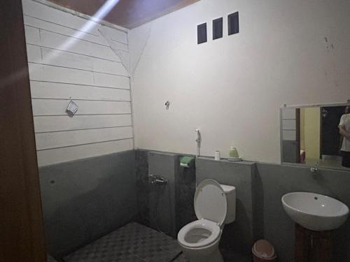 uma casa de banho com um WC e um lavatório em Senaru Garden Homestay em Senaru
