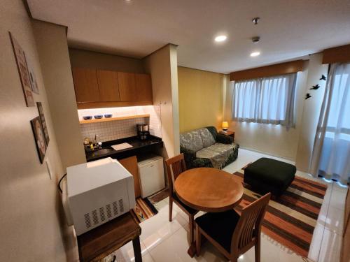a small living room with a table and a kitchen at Residence Flat 143 em Santana in Sao Paulo