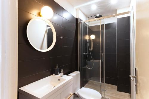 une salle de bain avec toilettes, lavabo et miroir dans l'établissement City in' BLUE : 1 à 4 personnes, à Carcassonne