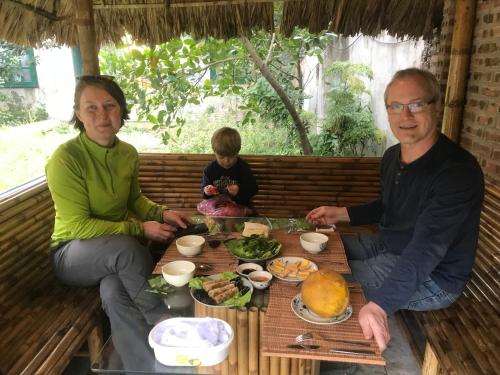 a man and woman sitting at a table with food at Tam Coc Eco House in Ninh Binh