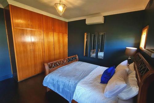 a bedroom with a large bed with a wooden headboard at Allawa- Central & Cosy Ballarat Art Deco in Ballarat