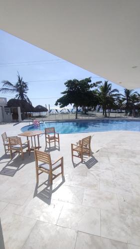 a group of benches sitting in front of a pool at Cabaña Apartamento En Coveñas - Fontaine Bleu in Coveñas