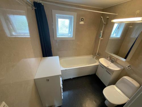 y baño con bañera, lavabo y aseo. en Åndalsnes Guest House - Cozy Apartment, en Åndalsnes
