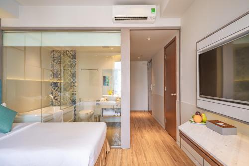 a bedroom with a large bed and a bathroom at Seaesta Nha Trang Hotel in Nha Trang