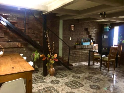 Habitación doble في سيوداد لوجان دي كويو: غرفة معيشة بها درج وطاولة وكراسي