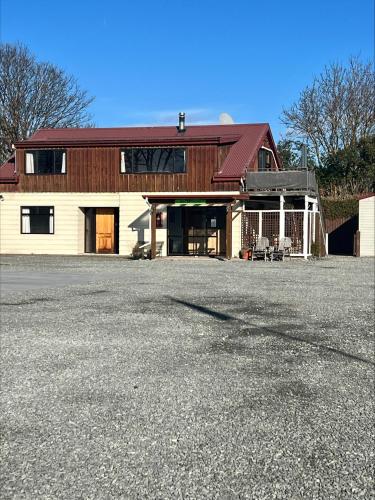 a large white barn with a red roof at Pinewood Motels in Fairlie