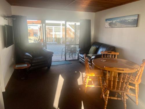 a living room with a table and a couch at Pinewood Motels in Fairlie