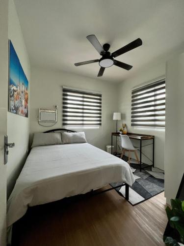 Schlafzimmer mit einem Bett und einem Deckenventilator in der Unterkunft Home in Aspire Prime Residences - Block 1 Lot 39 in San Fernando