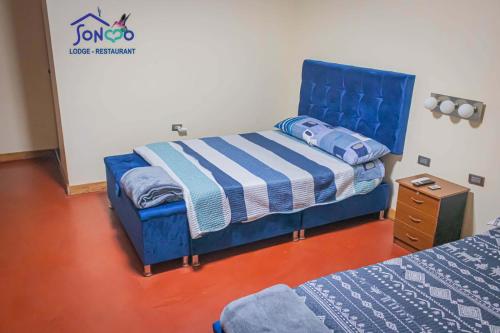 a room with two beds and a blue bed frame at SONCCO LODGE-RESTAURANT in Quillabamba