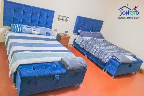 dwa łóżka siedzące obok siebie w pokoju w obiekcie SONCCO LODGE-RESTAURANT w mieście Quillabamba