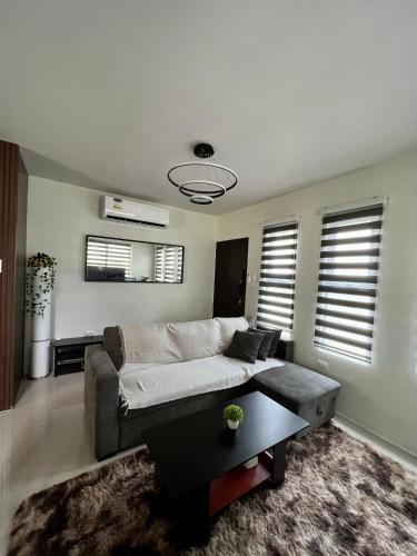 een woonkamer met een bank en een tafel bij Home in Aspire Prime Residences - Block 1 Lot 39 in San Fernando