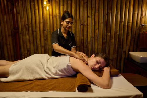 a woman getting a massage from a massage therapist at Maliekal Heritance Cherai Beach Cochin in Cherai Beach