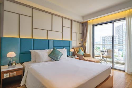 a bedroom with a large bed and a large window at Seaesta Nha Trang Hotel in Nha Trang