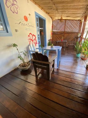 a room with a table and a bench on a wooden floor at Aurora Hostel in Pipa