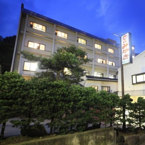 a building with lights on in front of some trees at 湯宿みゆきYuyado Miyuki in Kusatsu