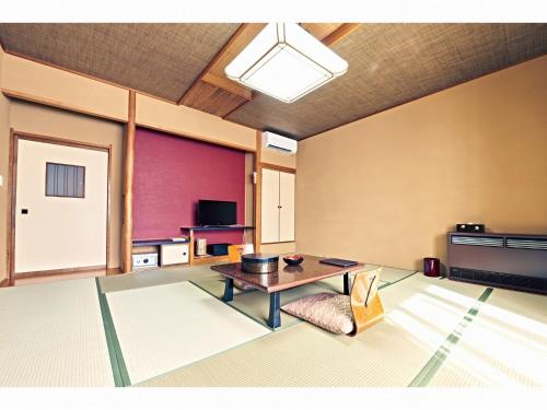 a living room with a table and a chair at 湯宿みゆきYuyado Miyuki in Kusatsu