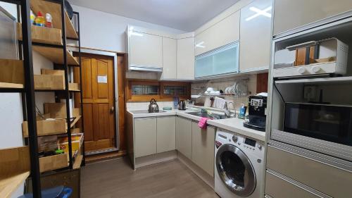 a kitchen with a washer and a washing machine at Ever Healing House in Namugil