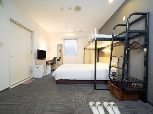 Super Hotel Tokyo Kameido في طوكيو: غرفة نوم مع سرير بطابقين ومكتب