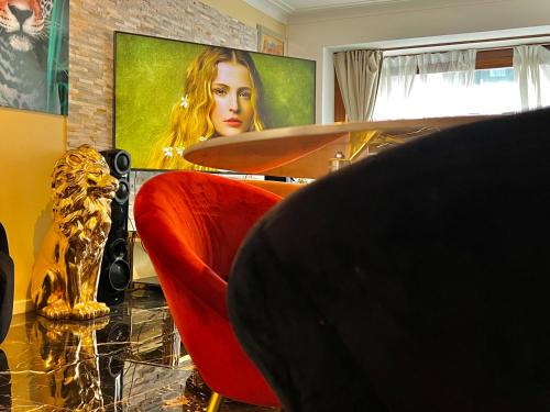 a living room with a red chair and a television at Luxury design apartment in Ostend